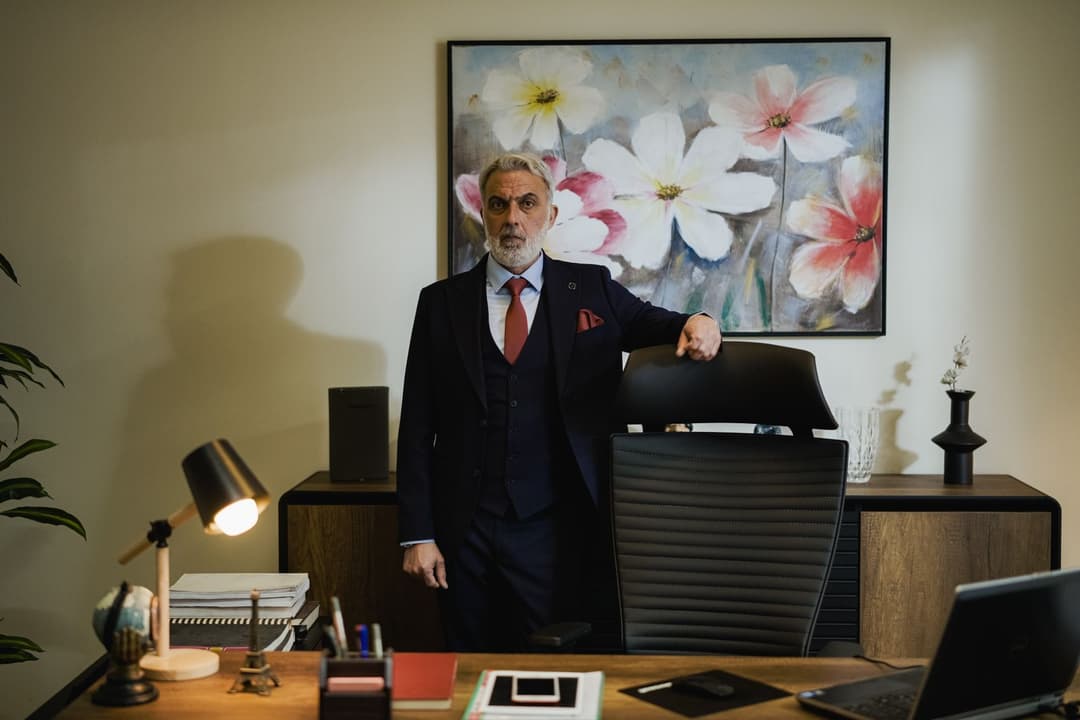 Professional reviewing paperwork at a desk in a bright office